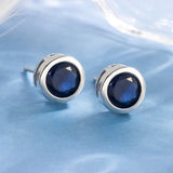 Boucles d'oreilles à clou avec lunette en saphir | Or blanc