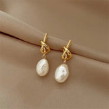 Boucles d'oreilles pendantes avec perles baroques en or