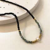 Collier avec perles noires, or et perles